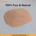 Close-up photo of a pile of fine-grained Himalayan Dark Pink Salt on a white table.