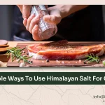 Himalayan salt blocks and crystals used in a rustic kitchen setting for cooking and serving.
